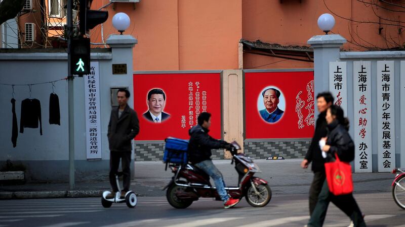 图为上海一家单位门内挂有习近平与毛泽东像的墙壁宣传画。(路透社)