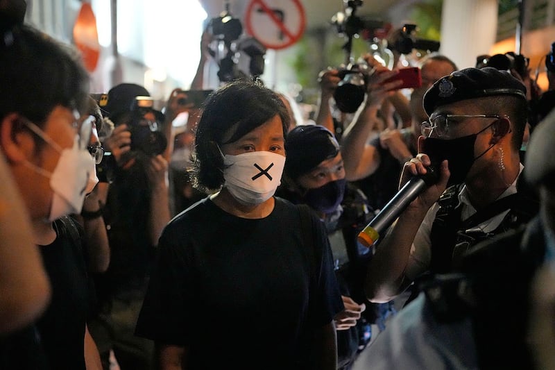 2022 年 6 月 4 日,一名警察要求一名民主活动人士离开香港维多利亚公园。(AP)