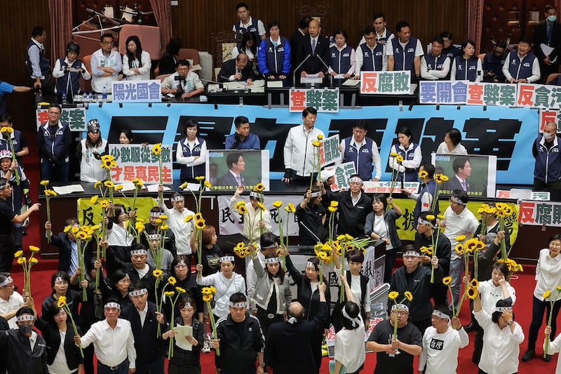 2024年5月21日,台湾的立法院漏夜审查《立法院职权行使法》修正草案,二读通过藐视国会罪、立法院调查权及听证权等多项条文。民进党立委在议场内手举向日葵高喊“反黑箱、反扩权”。(路透社)(路透社)
